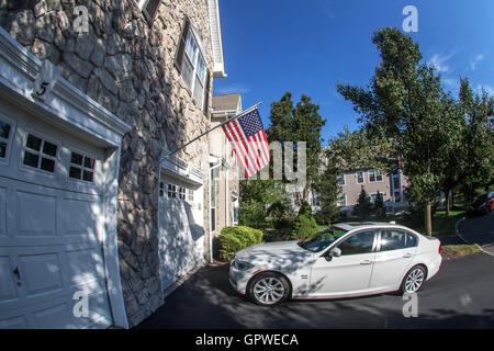 A private townhouse in New Jersey with a car in its driveway. Stock Photo