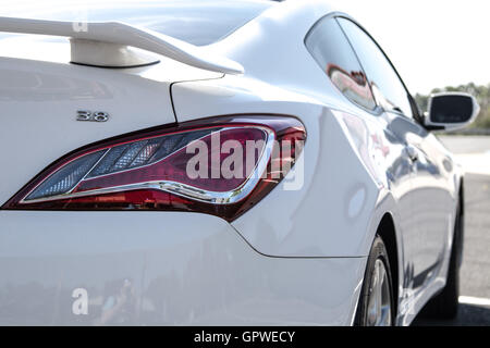 A back and side view of a white car in a parking lot. Stock Photo