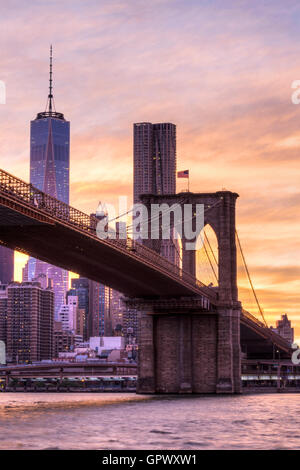 Sunset shot of the Brooklyn Bridge and One World Trade Center seen from the Brooklyn side of the bridge in New York. Stock Photo