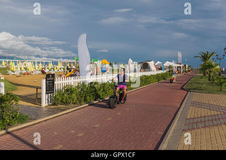 Young man on an Electric kick scooter in motion on a bicycle path. Stock Photo