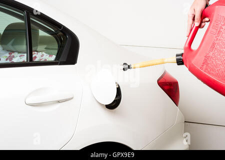 The use of a red gas can to till an electrical car Stock Photo