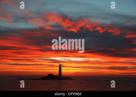 A fiery sky over St Mary's Lighthouse near Whitley Bay, Tyne and Wear, as warm weather is forecast for the week. Stock Photo