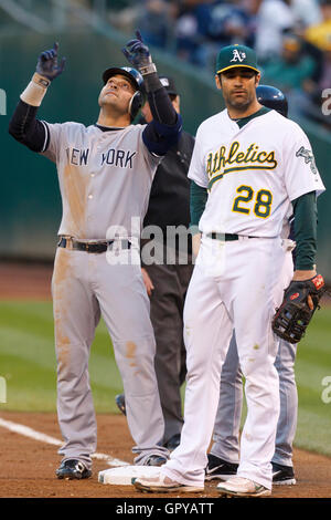 May 31, 2011; Oakland, CA, USA;  New York Yankees right fielder Nick Swisher (left) celebrates in front of Oakland Athletics right fielder Conor Jackson (28) after hitting a single during the fourth inning at Oakland-Alameda County Coliseum. Stock Photo