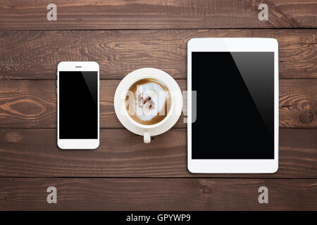 white phone tablet and coffee cup on wood table top view Stock Photo