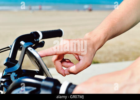 closeup of a young man using a smartphone mounted in the handlebar of a bicycle Stock Photo