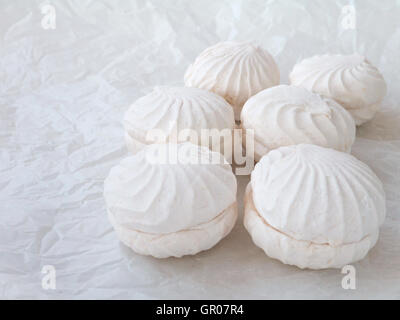 Off white marshmallow roses on the crumpled wax paper Stock Photo