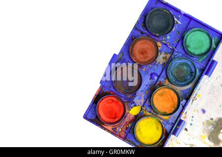 Top down view of old used watercolor box isolated on white. Copy space on left side. Stock Photo