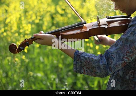 playing the violin in the field Stock Photo