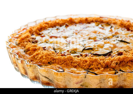 Close-up of homemade crustless zucchini quiche baked in a glass fluted dish isolated on white Stock Photo