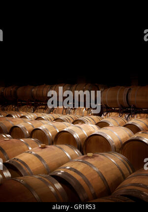 Wine cellar in warm ambiance.  Wooden wine barrels at a winery. Stock Photo