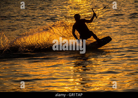 Silhouette Wakeboarder in action on sunset Stock Photo