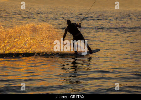 Silhouette Wakeboarder in action on sunset Stock Photo