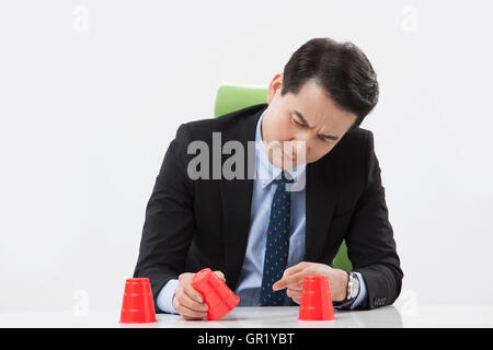 Portrait of middle aged businessman holding a cup among three frowning face Stock Photo