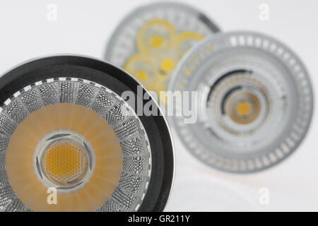 three LED GU10 bulbs with various plastic scattered light focusing on reflecting surface in the foreground Stock Photo