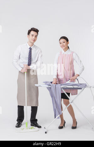 Young harmonious couple doing chores Stock Photo