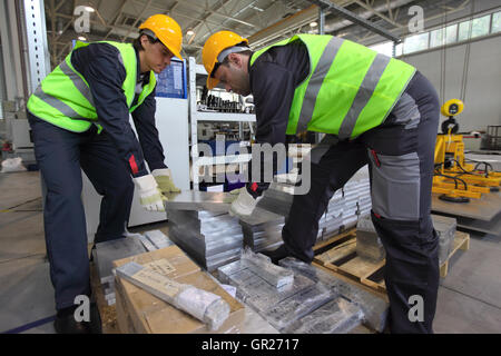 Workers taking aluminium billet at CNC machine shop Stock Photo