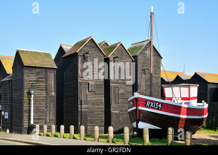 Net sheds and fishing boat on the Stade at Hastings Old Town, East Sussex UK Stock Photo