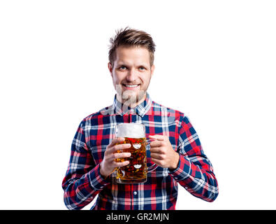 Hipster man in checked shirt holding beer, studio shot Stock Photo