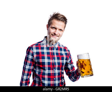 Hipster man in checked shirt holding beer, studio shot Stock Photo