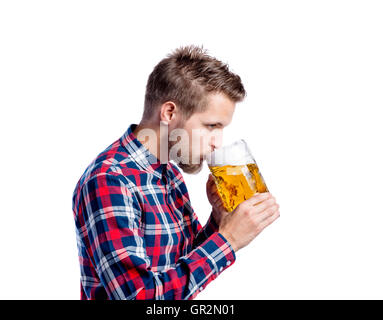 Hipster man in checked shirt drinking beer, studio shot Stock Photo