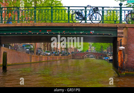 A bicycle parked on a bridge over a canal in Amsterdam, Holland Stock Photo