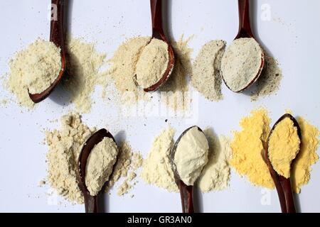 Different types of flour in vintage wooden spoons Stock Photo