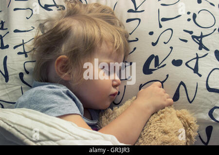 Toddler sleeping with teddy bear Stock Photo