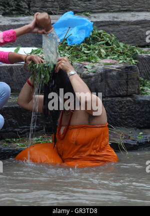 Kathmandu, Nepal. 06th Sep, 2016. A Hindu woman takes a bath ritual by using Dattiwan (sacred twigs) during Rishi Panchami festival on the bank of Bagmati river. Rishi Panchami, also known as Bhadraprada Sukla Panchami, is the last day of Teej Festival.On the occasion, women take a bath early in the morning to mark Rishi Panchami and seek forgiveness for ‘sins' committed during monthly periods.Hindu women offer prayers to Saptarshis (seven saints). © Archana Shrestha/Pacific Press/Alamy Live News Stock Photo