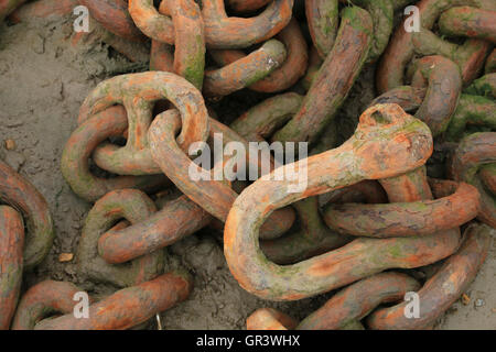 Rusty chain on shingle Stock Photo