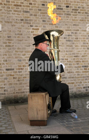 Busker known as 'Fire Tuba' playing his modified musical instrument in a unique street performance on the South Bank, London, UK Stock Photo