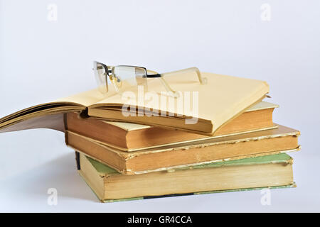 Closeup of several old books and glasses on bright background Stock Photo