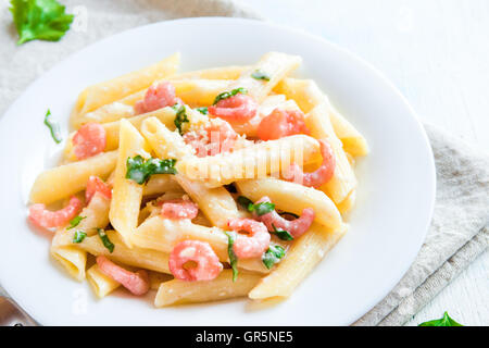 Penne pasta with shrimps, cream sauce and grated parmesan cheese Stock Photo