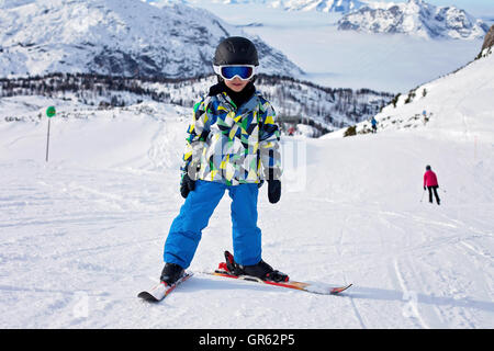 Cute little boy, skiing happily in Austrian ski resort in the mountains, wintertime Stock Photo