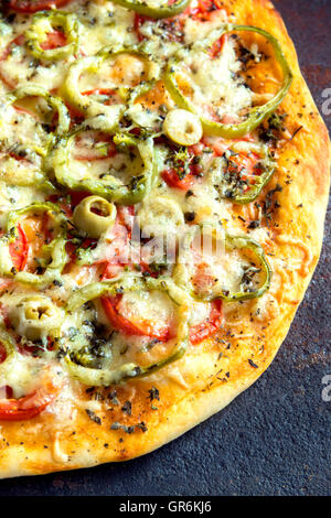 Homemade rustic spicy vegetable pizza over old metal background close up Stock Photo