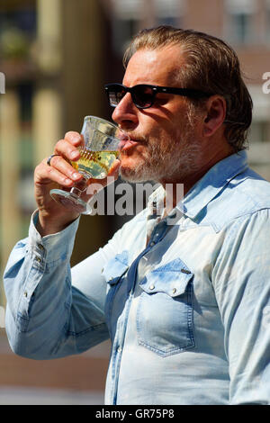 Man With A Denim Shirt Drink Alcohol Stock Photo