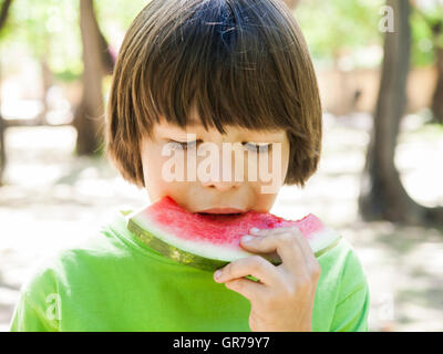 Boy Child Eating Watermelon During Sunny Day Stock Photo