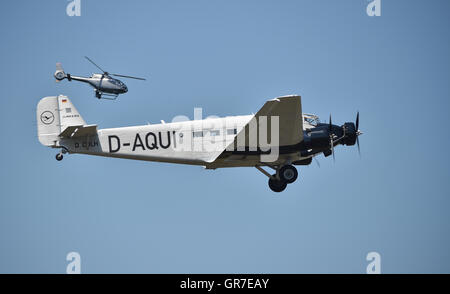 Propeller plane Ju 52 and helicopter flying over Hesse, Germany