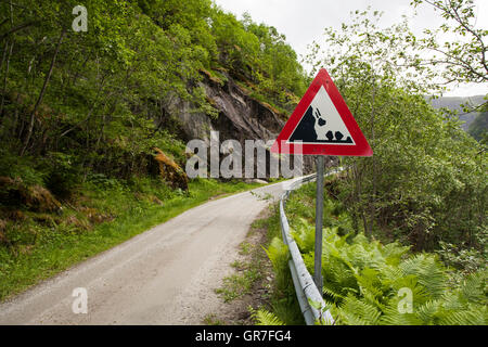 Falling rocks warning sign by narrow mountain road, Hjølmo Valley, Norway Stock Photo