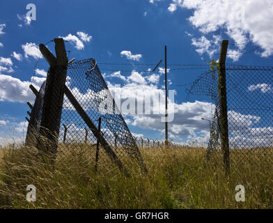 hole in military security chain link fence Stock Photo
