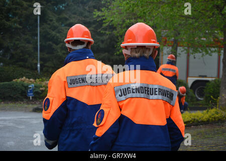 Two Young Fireman In Uniform Standing On The Road Stock Photo