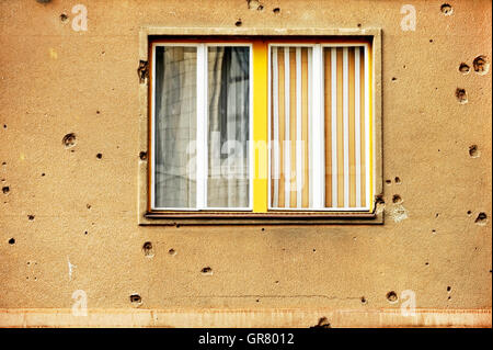 Traces of bullets on a building facade destroyed by war Stock Photo