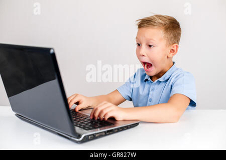 shocked boy using laptop with open mouth Stock Photo