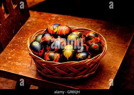 Brightly Painted, Yellow, Red, Black Easter Eggs In Basket Stock Photo