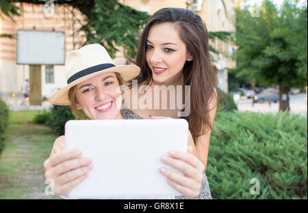 Two girlfriends taking selfie with a tablet Stock Photo