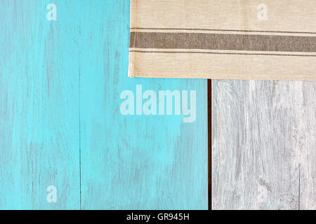Rustic blue and white painted wooden table with a small tablecloth, view from above, copy space. Stock Photo