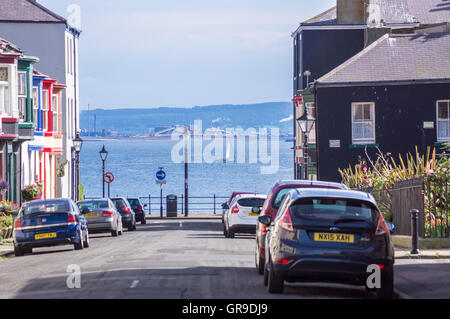 A yacht in Hartlepool Bay seen from a street of Victorian terraced houses, The Headland, Hartlepool, County Durham, England Stock Photo