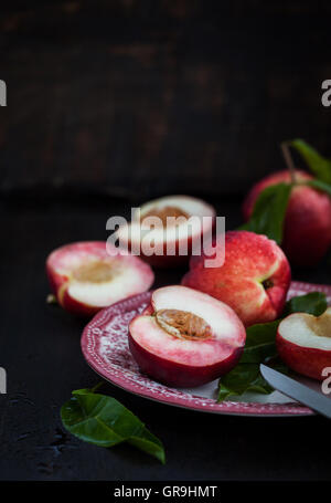 Plate of fresh nectarines on dark background Stock Photo