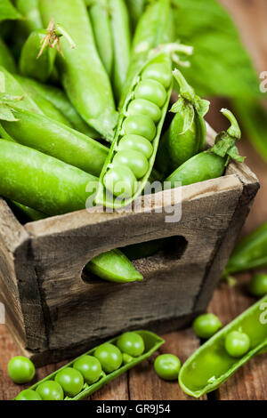 Fresh ripe green peas in wooden box Stock Photo