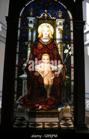 Stained glass image of Virgin and child Jesus backlit against window of gallery in Vatican Museum Vatican City Rome Stock Photo