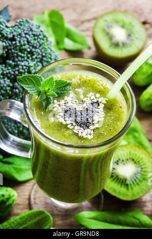 Green vegetable and herbs smoothie with heart of poppy and sesame seeds. Love healthy raw food concept. Stock Photo